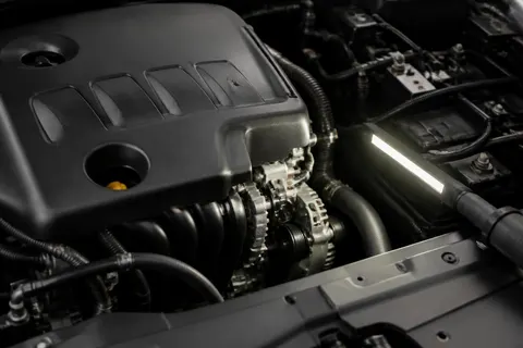 Technician diagnosing an engine problem under the hood of a customer vehicle