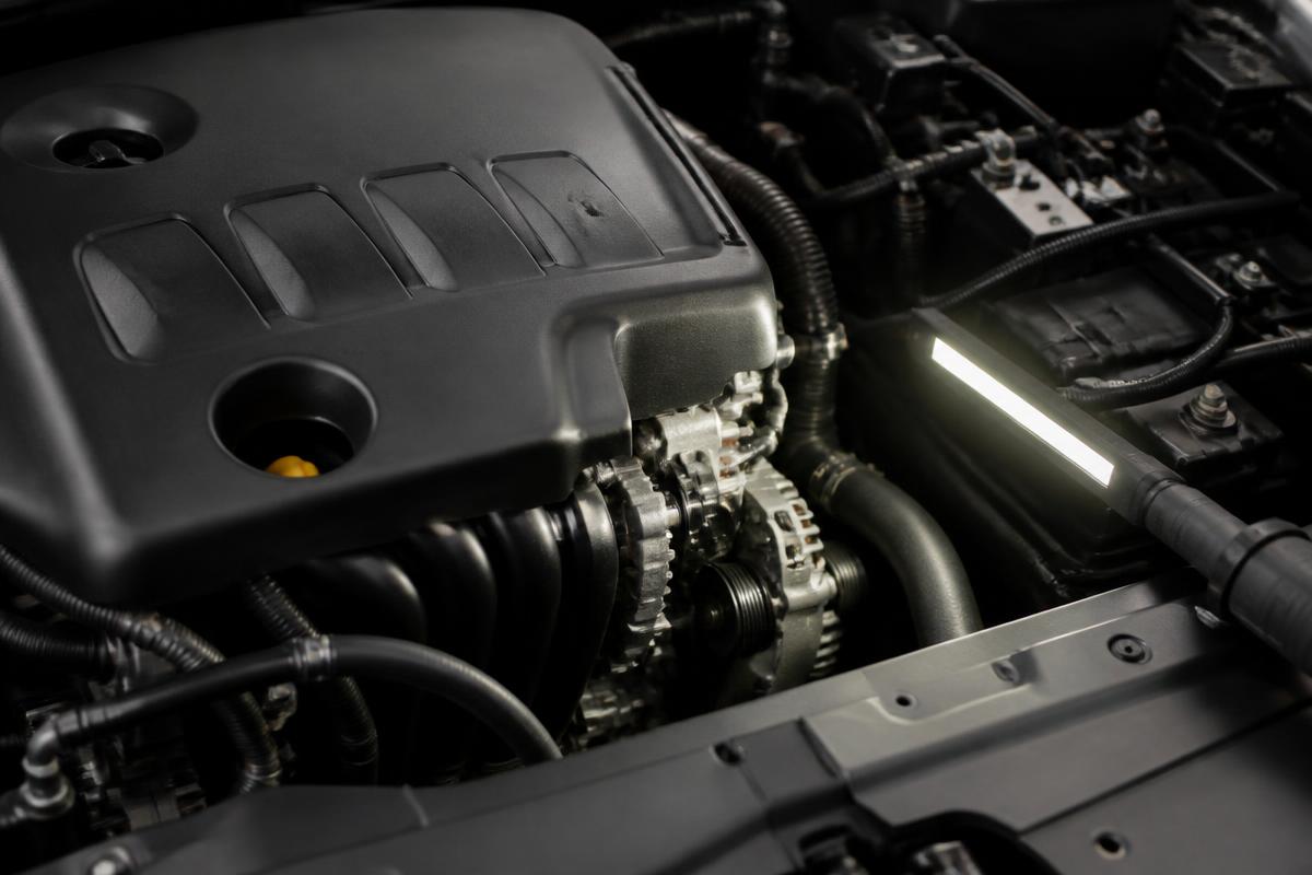 Technician diagnosing an engine problem under the hood of a customer vehicle