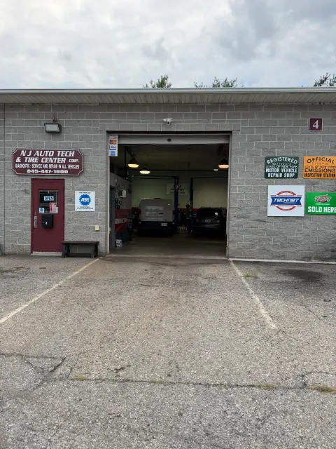 NJ Auto Tech Automotive Specialist storefront entrance with New York registered motor vehicle repair shop and official emissions inspection station signs in Wappingers Falls, NY