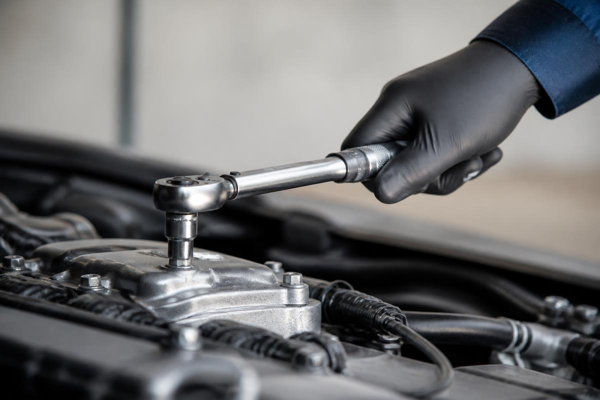 Technician performing a final quality check on a completed engine-bay service before handoff