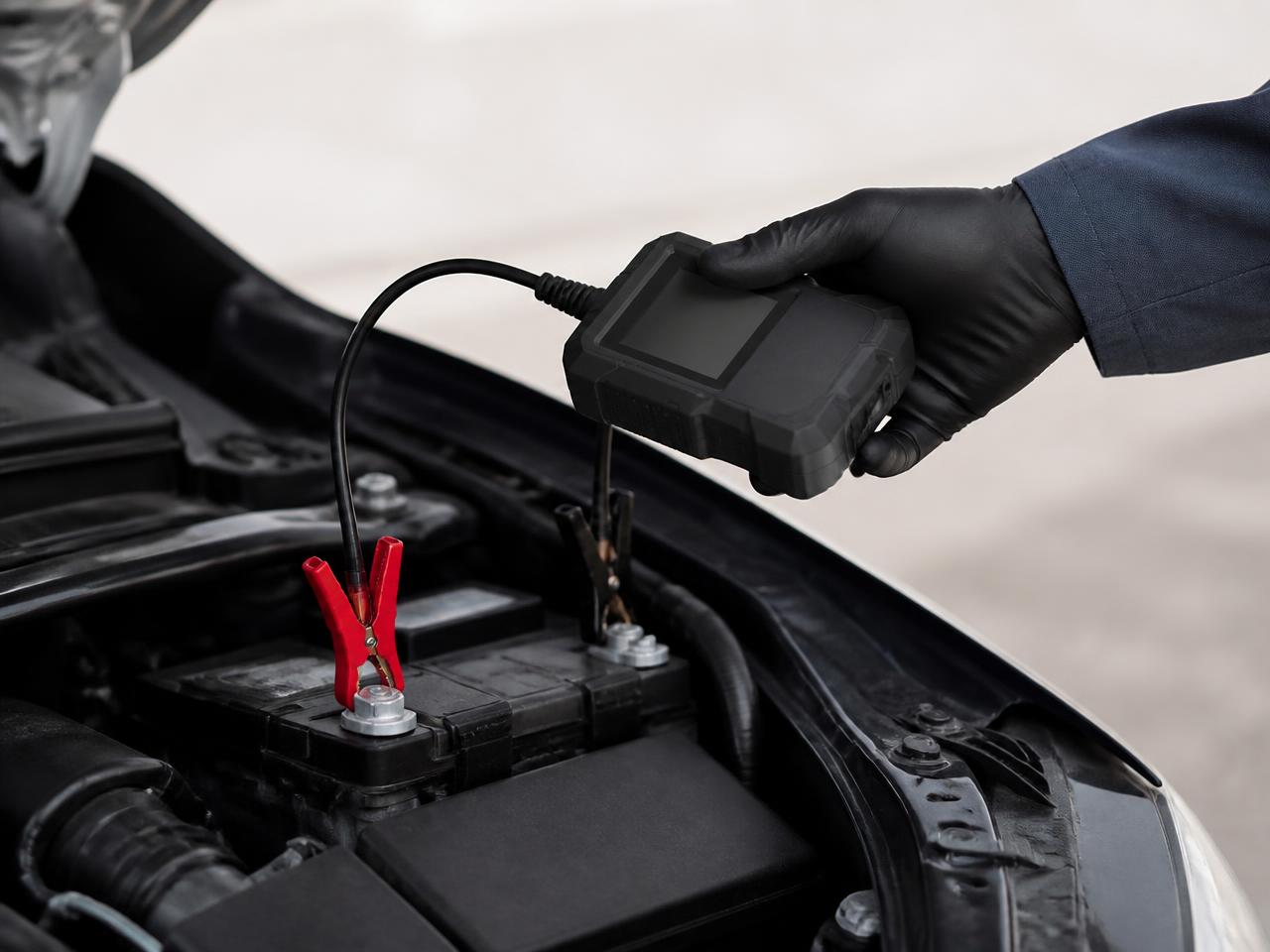 Battery tester connected to a vehicle battery during multi-point automotive service